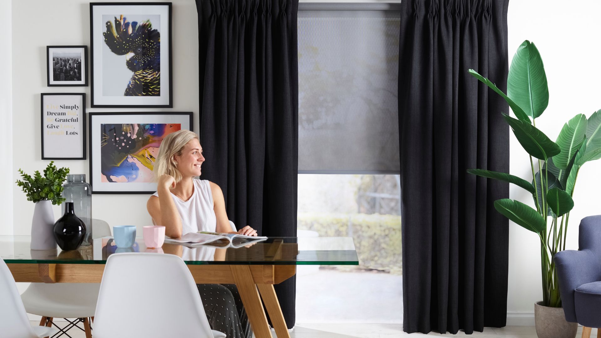 Dark grey pinch pleat curtains paired with light grey inner roller blinds