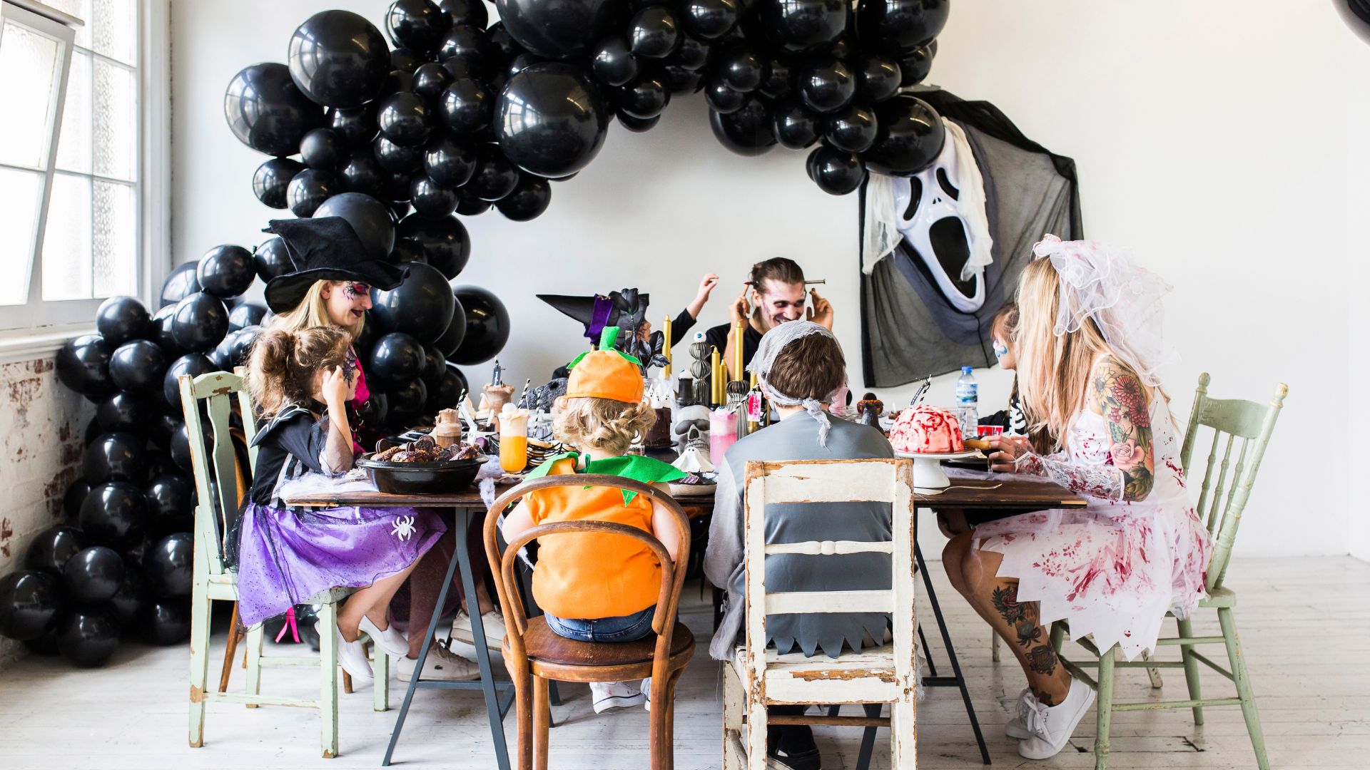 Halloween Table Setting with mismatching chairs & black balloon garland