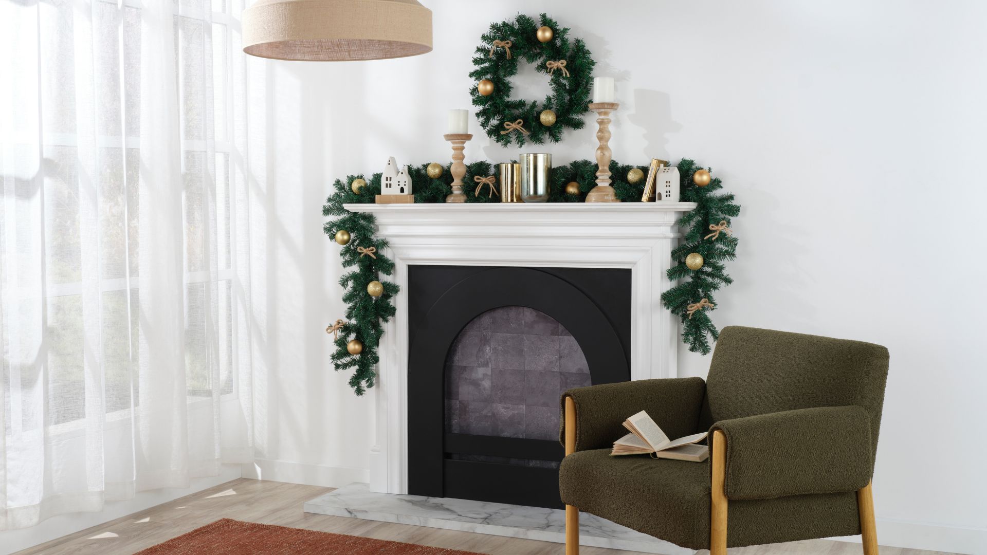 Christmas wreath and tinsel above a fireplace, decorated with gold baubles & ribbons