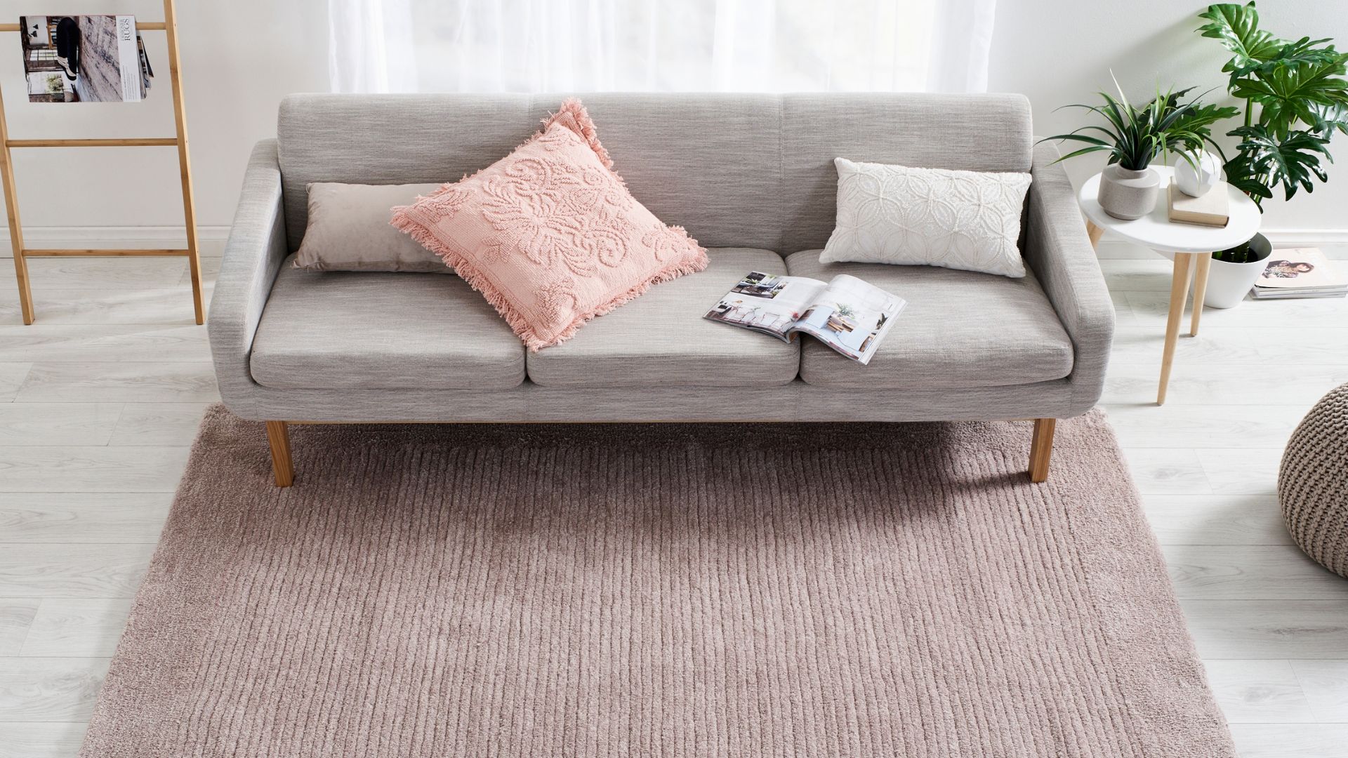 Muted pale dusty pink shaggy rug with textured stripe details in a living room space