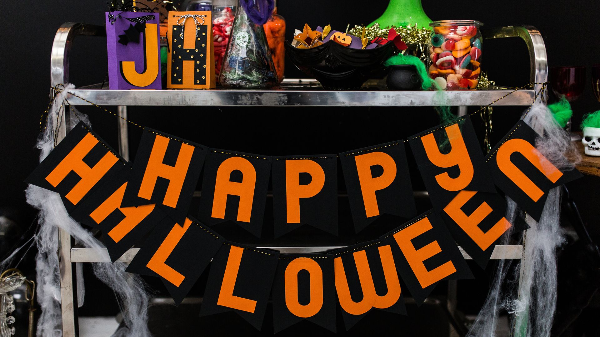 Treat trolley decorated with fake cobwebs and Halloween banner